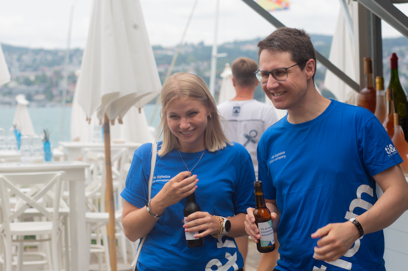 Zwei Menschen lachen mit Getränken am Zürichsee Zwei Menschen lachen mit Getränken am Zürichsee